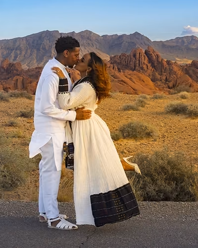 Couple standing close together against towering red sandstone walls during a Valley of Fire portrait session