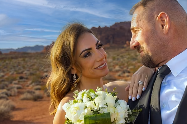 Bride and groom during an outdoor desert wedding ceremony at Valley of Fire as the sun sets behind the sandstone cliffs